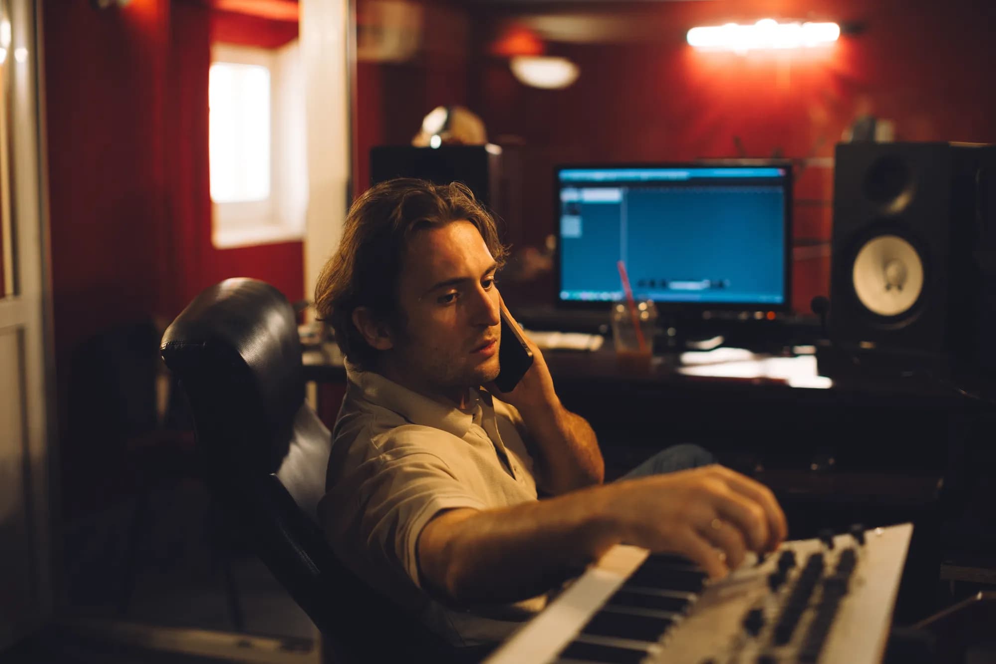 A composer and a music supervisor discussing a score at the piano.
